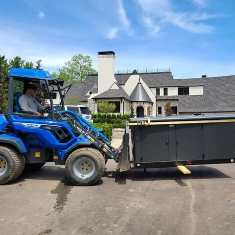 Powerhouse Generator -a blue tractor hauling a black generator